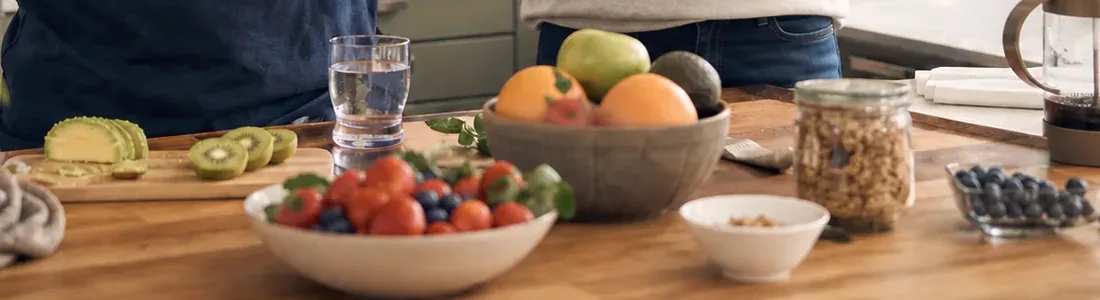 Fresh fruit, vegetables and water prepared on a kitchen counter